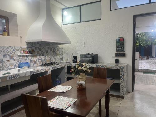 a kitchen with a wooden table and a stove top oven at Casa Azul en Centro de Mérida in Mérida