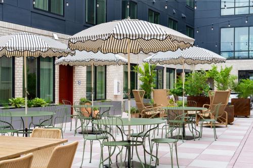 an outdoor patio with tables and chairs and umbrellas at The Gilmore, an AvantStay Hotel in Nashville