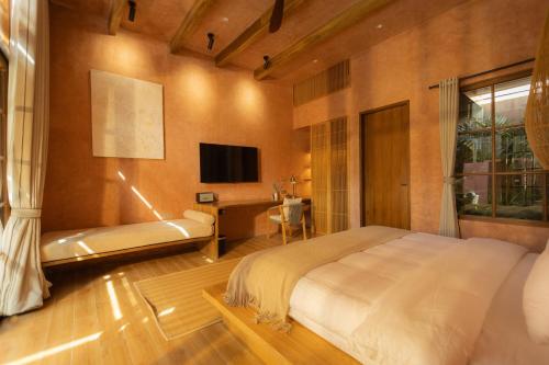 ein Schlafzimmer mit Bett, Schreibtisch und Fernseher in der Unterkunft Lio Lio Suites Private Pools in El Nido