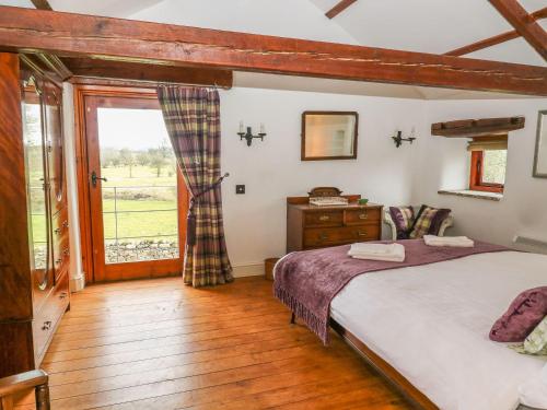 a bedroom with a bed and a window at The Bothy in Leyburn