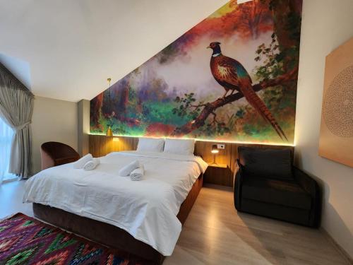 a bedroom with a large bed and a painting on the wall at MIK Hotel Korça in Korçë