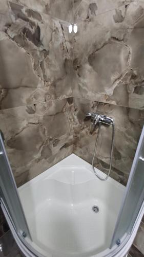 a bathroom with a bath tub with a marble ceiling at Apartment in Zentrum Skandi in Vinnytsya