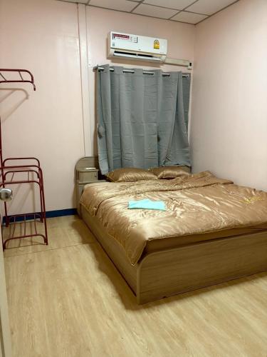 a bedroom with a bed with a blue item on it at Worsakornrit Homestay in Bangkok