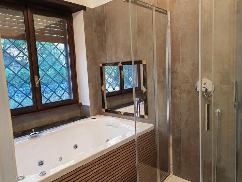 a bathroom with a tub and a glass shower at Blue emotion, into wellness & wilderness in Albano Laziale