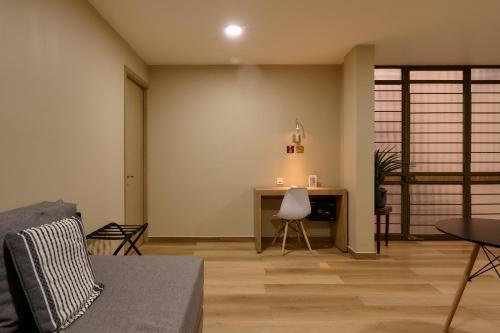 a living room with a table and a desk at Suites el Consuelo in Oaxaca City