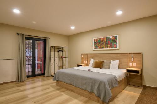 a bedroom with a bed and a painting on the wall at Suites el Consuelo in Oaxaca City