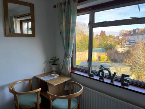 a window with a table and two chairs in a room at Double Room with Garden View at Love & Peace Petts Wood in Orpington