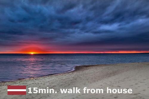 a sunset on a beach with the words walk from house at Rabarberi LV just 15min walk to SeaSide in Saulkrasti