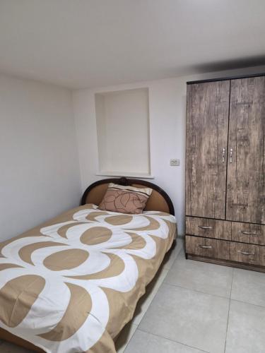 Summer Garden في تبليسي: غرفة نوم مع سرير وخزانة خشبية