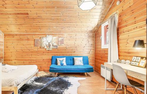 a blue couch in a room with wooden walls at Chalet de Seyne in Seyne