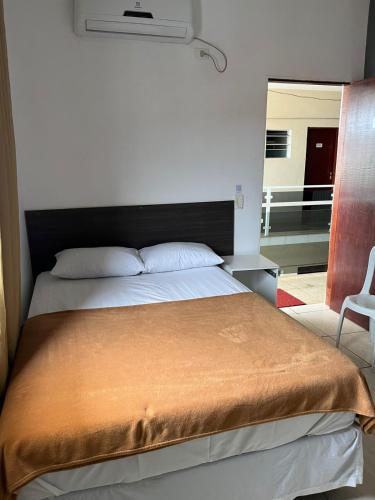 a bedroom with a large bed with a black headboard at Hotel Araçariguama in Araçariguama