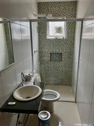 a bathroom with a toilet and a sink and a shower at Hotel Araçariguama in Araçariguama