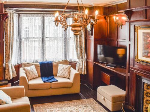 a living room with a couch and a tv at Heritage Lodge in Rhyl