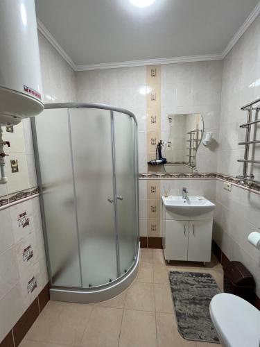 a bathroom with a glass shower and a sink at Готель Козацький in Zvenyhorodka