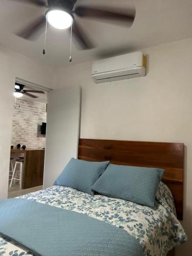 a bedroom with a blue bed and a ceiling fan at Majos Aldea Tulum in Tulum