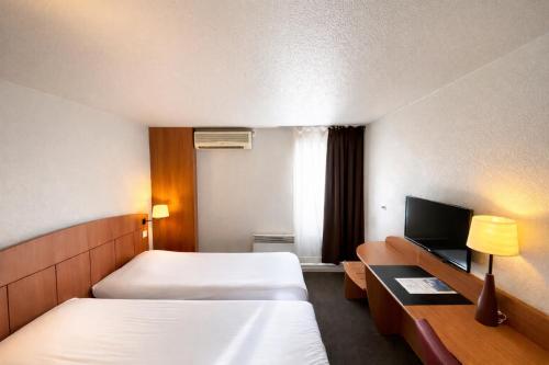 a hotel room with two beds and a television at Kyriad Montargis Amilly in Amilly