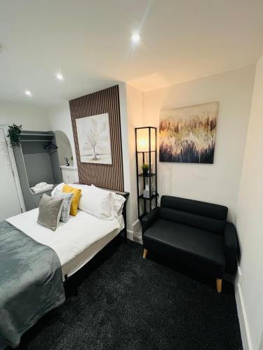 a bedroom with a bed and a black chair at Yastayzzz Studio 2 Worcester House with Free Parking in Worcester