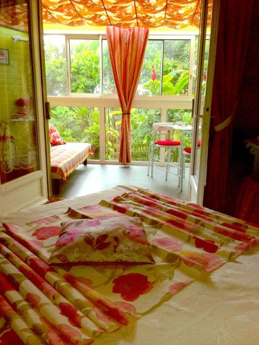 a bed in a room with a large window at Pinpin D'amour in Basse Vallée