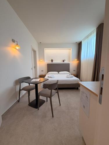 a hotel room with a bed and a table and chairs at Ab aparthotel in Gizzeria