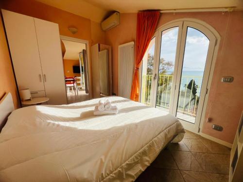 a bedroom with a large bed and a large window at Suite La Brezza - Luxury Sanremo in Sanremo