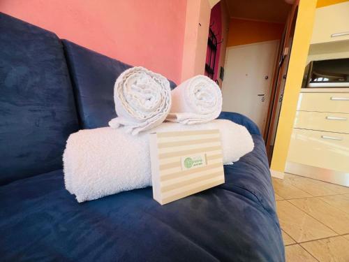 a blue couch with towels and a box on it at Suite La Brezza - Luxury Sanremo in Sanremo