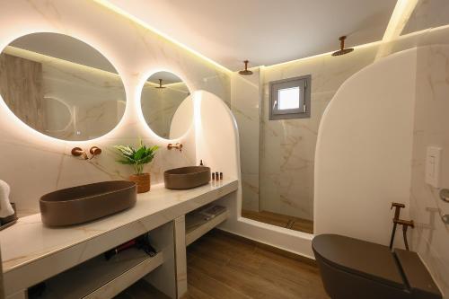 a bathroom with two sinks and two mirrors at Aerial Apartments in Karterados