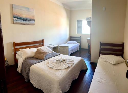 a bedroom with two beds with a bow on it at Hotel Chão Mineiro in São Thomé das Letras