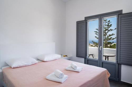 a bedroom with a bed with two towels on it at Aerial Apartments in Karterados