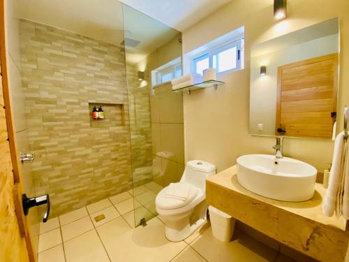 ein Badezimmer mit Waschbecken, Toilette und Dusche in der Unterkunft Club Vergel Resort in Bernal