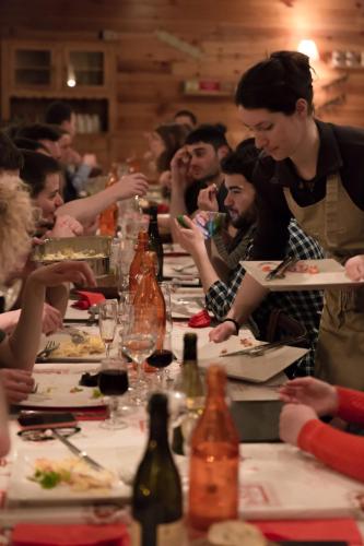 a group of people sitting at a long table eating food at Hotel Les Flocons in Les Deux Alpes