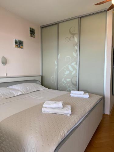 a bedroom with two white towels sitting on a bed at Apartment Ornik in Crikvenica