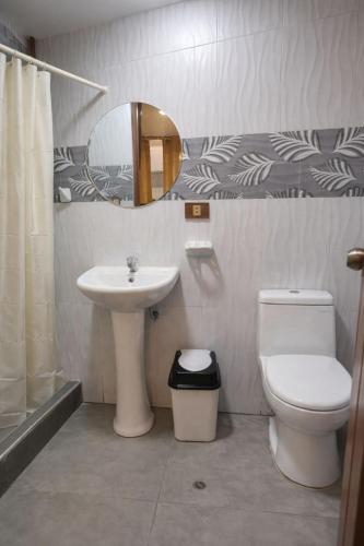 a bathroom with a sink and a toilet and a mirror at Hospedaje chakana inn in Cusco