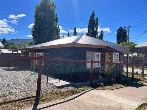 a small house with a fence in front of it at Departamentos Confluencia in Cochrane