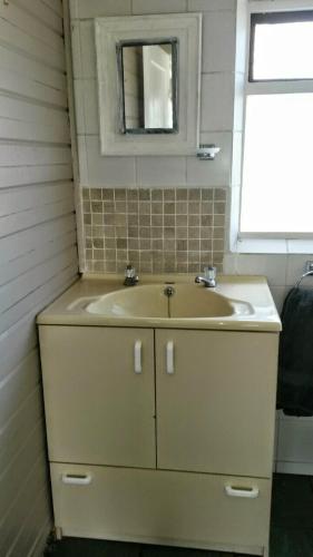 a bathroom with a sink and a mirror at Ons Strandhuisie N5 in Pearly Beach in Pearly Beach