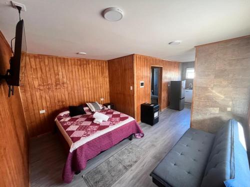 a bedroom with a bed and a couch in it at Departamentos Confluencia in Cochrane