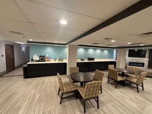 a waiting room with tables and chairs and a counter at Quality Inn & Suites Detroit Metro Airport in Romulus
