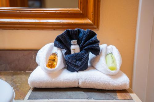 a towel pile with two bottles of soap and a mirror at Daniels Summit Lodge in Wallsburg