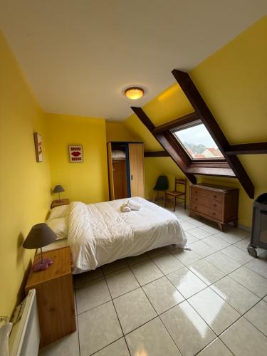 a bedroom with a bed in a room with yellow walls at Le secret d'Opale in Wissant