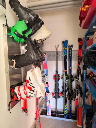 a room with skis and ski equipment on a wall at Cèsa Emily in Campitello di Fassa