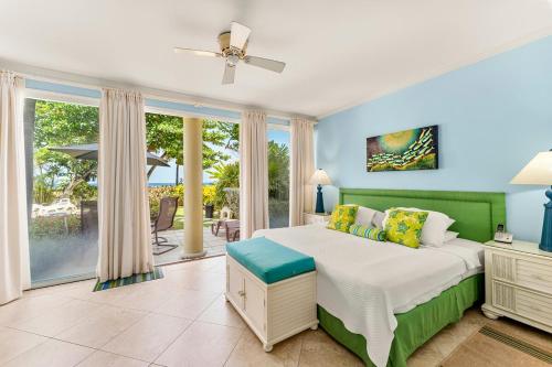 a bedroom with a bed and a large window at 101 Sapphire Beach Barbados in Christ Church