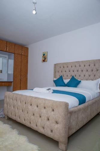 a bedroom with a large bed with a tufted headboard at Chesum's suites in Eldoret