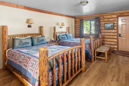 a bedroom with two beds in a log cabin at Daniels Summit Lodge in Wallsburg