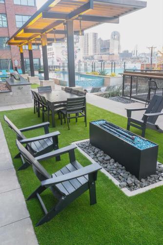 a group of benches and tables on a roof at Downtown Dallas ELLUM OASIS with Balcony, Pool, Rooftop Deck, Gym, Queen Bed, King Sleeper Sofa, 2 Twin Sleeper Chairs, and Parking Garage in Dallas