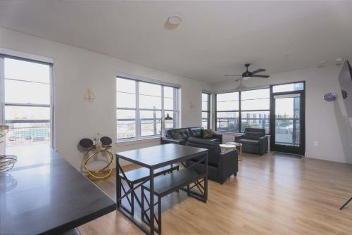 a living room with a couch and a table at Downtown Dallas ELLUM OASIS with Balcony, Pool, Rooftop Deck, Gym, Queen Bed, King Sleeper Sofa, 2 Twin Sleeper Chairs, and Parking Garage in Dallas