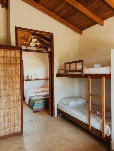 a room with two bunk beds and a mirror at Kahuma in Imbituba