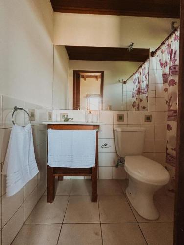 a bathroom with a toilet and a sink at Kahuma in Imbituba