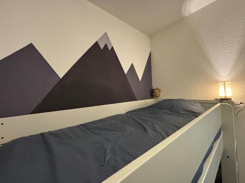 a bedroom with a bed with mountains on the wall at Pied des pistes, piscine, jacuzzi in Flaine