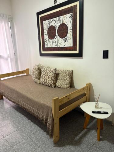 a bed in a room with a table and a picture at Santa Genoveva in Neuquén
