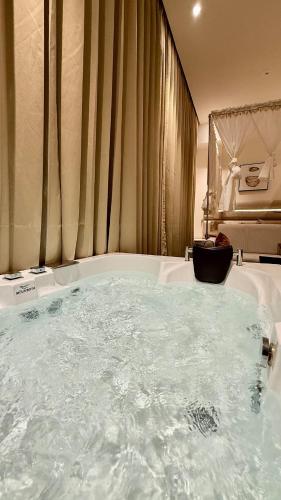 a bathroom with a large tub with water in it at Sundowner Hive115 Jacuzzi studio Large grdan patio in Gurgaon