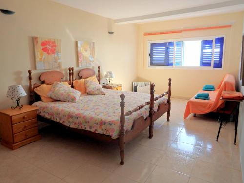 Un dormitorio con una cama y un escritorio y una ventana. en El Varadero, en Igueste